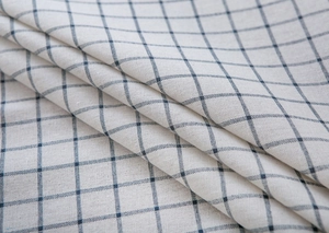 Close-up of Mediterranean blue plaid cotton linen fabric texture with rustic fringe details