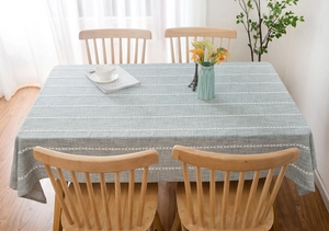Close-up of a light grey cotton linen tablecloth with white geometric hollowed stripes