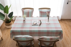 Detailed view of green plaid tablecloth with delicate lace trim and matching cushions