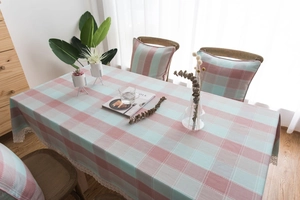 Detail of pink and green plaid tablecloth featuring elegant white lace embroidery borders