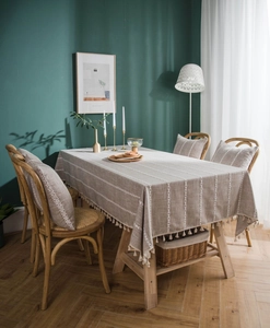Detailed close-up of brown cotton linen tablecloth with white embroidery and tassel fringe
