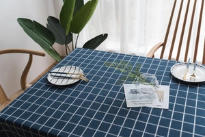 Detailed view of dark blue checkered linen tablecloth with white grid pattern texture