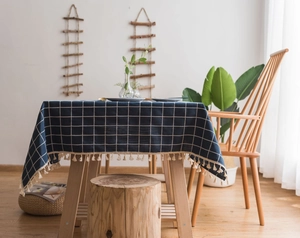 Detail of navy blue plaid tablecloth with elegant beige tassels on heavy linen fabric