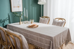 Detail of embroidered stripes and handmade tassels on grey cotton linen tablecloth