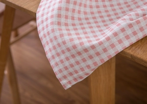 Detailopname van roze en wit geruit katoenen linnen tafelkleed met geweven textuur