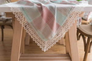 Detail of mint green plaid tablecloth featuring elegant wide white lace embroidery edges