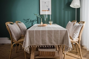 Close-up of linen tablecloth with white stripes and elegant fringe tassels