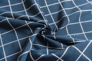 Close-up of deep blue plaid fabric with white grid pattern and fine cotton linen texture