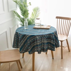 Detail of blue Bohemian geometric round tablecloth with linen texture on a wooden table