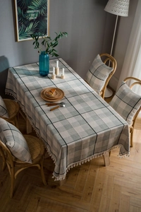 Detail of gray plaid cotton linen tablecloth with elegant white fringe tassels