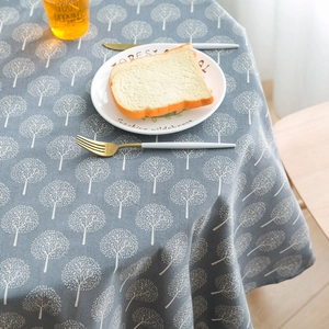 Detailed close-up of blue-grey cotton linen tablecloth with white tree pattern print