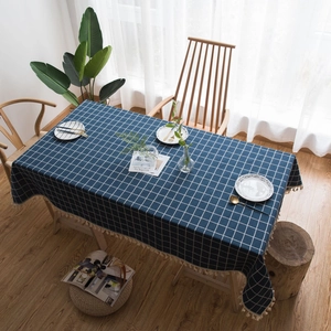 Navy blue checkered cotton linen tablecloth with cream tassels in a cozy home setting