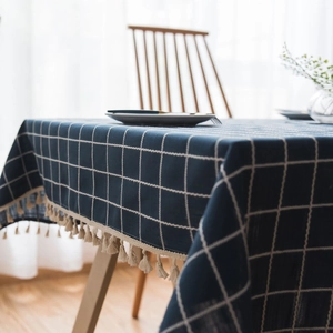 Navy blue checkered cotton linen tablecloth with beige tassels in a modern home setting