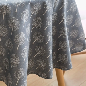 Close-up of Nordic style cotton linen tablecloth with white tree pattern and neat edges