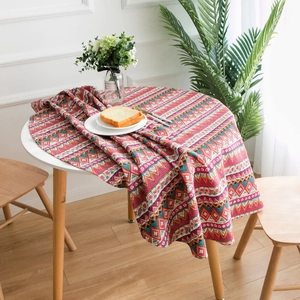 Bohemian style round linen tablecloth with red geometric patterns on white dining table