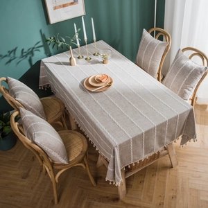 Linen rectangle tablecloth with white lace stripes and tassels in a rustic home setting