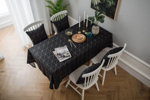Detail view of modern black and white geometric tablecloth with matching cushions set