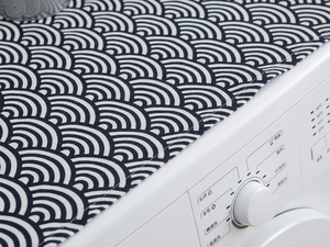 Detail of navy Seigaiha wave pattern fabric with high-quality stitching on a washer top