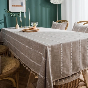 Brown boho cotton linen tablecloth with leaf embroidery and tassels on dining table