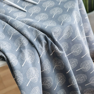 Close-up of gray-blue cotton linen tablecloth with white abstract tree print patterns