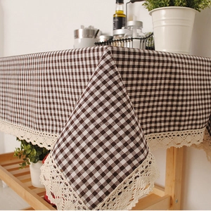 Brown and white Vichy checkered tablecloth with cream lace borders on a wooden shelf