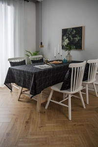 Detail view of modern black and white geometric tablecloth set with matching cushions