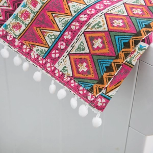 Red Bohemian geometric dust cover for fridge or washer with white pom-pom fringe details