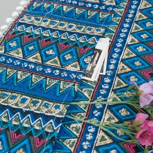 Detailed view of bohemian geometric fabric texture with side pockets and white tassels
