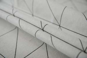 Detail of modern black geometric triangles on textured cotton linen tablecloth fabric