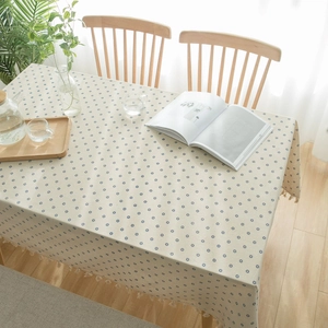 Detailed view of floral cotton linen tablecloth with blue daisy prints and fringe edges