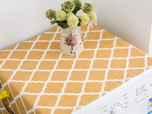 Detail showing ginger yellow geometric pattern dust cover on top of a washing machine