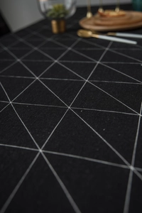 Close-up of black cotton linen tablecloth with white geometric triangle line patterns