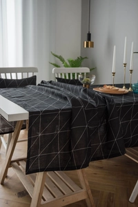 Detail of modern black and white geometric cotton linen tablecloth on a dining table