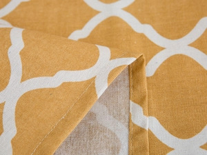 Macro detail of ginger yellow geometric clover pattern on textured linen fridge cover