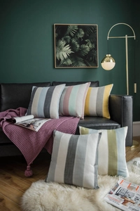 Macro detail of high-quality woven stripe cushion covers in various colors on a black sofa