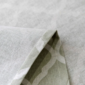 Macro shot of fine edge stitching and geometric pattern on light green fabric