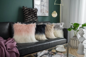 Detailed view of luxury faux fur cushion covers in multiple ombre colors on a black sofa