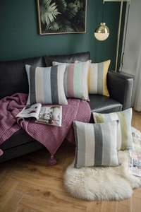 Detailed texture of thick woven striped throw pillows on a luxury leather sofa
