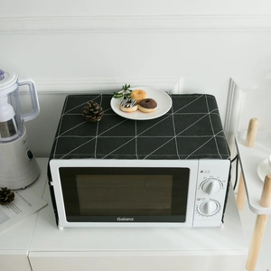 Modern black geometric microwave dust cover with side storage pockets and white patterns