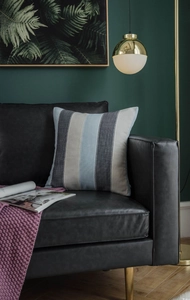 Detailed texture of colorful striped sofa cushion on black leather sofa in modern room