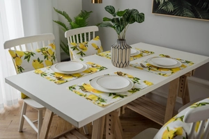 Lemon print placemats and cushions in a rustic table setting with greenery