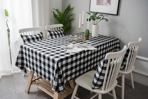 Detailed top view of black and white buffalo plaid tablecloth with matching cushion cover