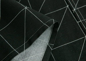 Detail of high-density black fabric with white geometric lines and reinforced stitching