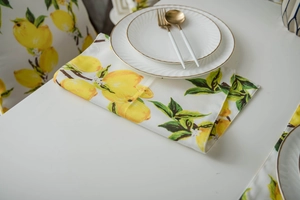 Detailed view of yellow lemon print placemat and chair cover on a white dining table