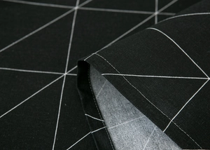 Detail view of the fine stitching and geometric triangle pattern on black fabric