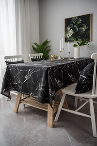 Detail of Nordic black marble pattern tablecloth and matching cushion covers on a table