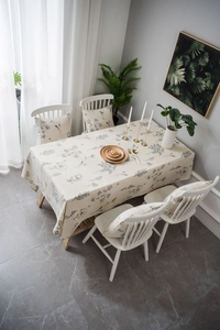 Detail of linen tablecloth with grey floral prints and matching chair cushions