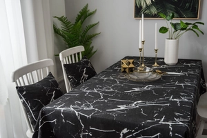 Detailed view of black marble print tablecloth and matching cushion in Nordic style