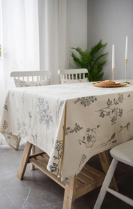 Detailed view of rectangle cotton linen tablecloth with black floral print and edge stitching