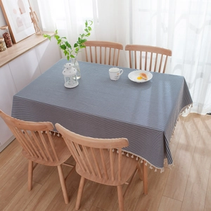 Detailed view of navy blue striped tablecloth with white decorative fringe on table edge